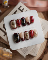 Gilded Merlot short coffin press-on nails with merlot cat-eye shimmer and gold rose reliefs