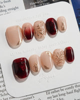 Gilded Rouge in extra short oval shape with amber red polish and gold leaf texture