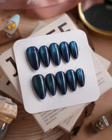 Glint Aurora press-on nails in medium almond shape — deep teal cat eye shimmer