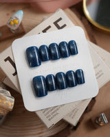 Glint Midnight press-on nails in short square shape — deep teal cat eye shimmer