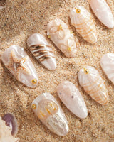 Golden Bay handmade nails with pearly shells, gold wire flowers, and wave texture