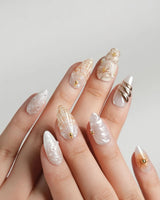 Golden Bay resort-luxe nails with milky white shimmer, shells, and gold florals