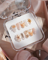 Golden Bay extra short almond nails with pearly shells and gold wire florals