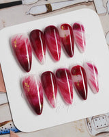 Gone with the Wind medium stiletto press-on nails with marbled burgundy and gold foil accents