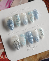Great Barrier Blue modern ocean nails with shell-carved texture and shimmering blue polish