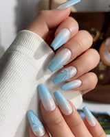 Macro detail of handmade baby blue nails with ombre and bow texture
