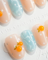 Juicy Summer short oval nails with 3D tangerines, baby blue, nude, and white dots
