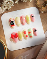Kiki’s Enchanted Picnic press-on nails — Pastel Multicolor, Hand-painted Cat & Bow. handmade nail art by Joyee Nails