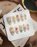 Kiln Spring press-on nails in short almond shape — Colorful Butterflies, Hand-painted Golden Outlines & Glitter Petals.