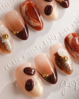 Close-up of Latte Coffee press-on nails with brown marble, coffee beans and creamy foam details