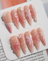 Lily-Nocturne press-on nails in long stiletto shape — Soft Peach Pink, 3D Lilies & Shell Textures.