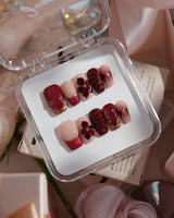 Lily Rouge short coffin press-on nails with red cat-eye French tips and 3D flowers
