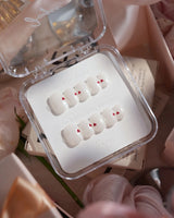 Little Luck nail art close-up showing milky white red heart nails details