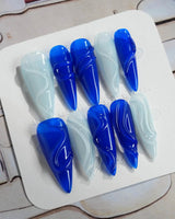 Majorelle Blue long stiletto nails with high-gloss blue swirls and silver-white details