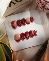 Molten Rouge press-on nails with molten red cat-eye gel, nude base and gold crystal accents