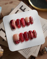 Molten Rouge short coffin press-on nails with deep red cat-eye and gold crystal details