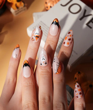 Monster Mash handmade Halloween press on nails with orange pumpkin, vampire, skeleton, stitches and bats on a sheer nude base - image 1