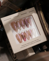 Neon Kiss press-on nails with pink chrome butterfly wings, pearls and sculpted gold line details