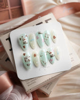 Otter Momo medium almond nails with otter nail art, petals, and seashell details