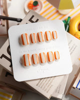 Parasol extra short squoval press-on nails with retro tangerine stripe design