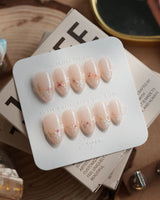 Petal Press press-on nails in extra short almond shape — Warm Creamy Skin Tone, Hand-painted Florals & glitter Shimmer.
