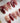 Red Christmas press-on nails with candy cane and snowflake details