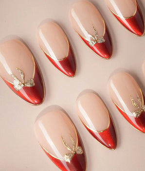 Bow French handmade press-on nails featuring nude base red chrome french gold outline bow accent