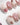 Glossy French nails with sculpted flower embellishments