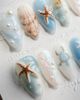 Shell Picking short almond press-on nails with sky-blue jelly base and 3D seashells