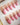 Short almond French nails with pink and gold bow tips