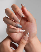 Silver Shore medium almond press-ons with nude gloss, silver chrome, and 3D flower detail