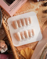 Spiral Twist nail set with pearl nude base, silk-like texture, and daisy nail art