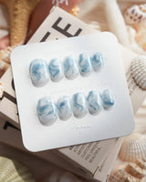 Starry River extra short squoval nails with blue-white marble flow and glossy aqua shine