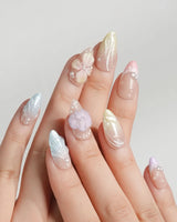 Sunbathing pastel island nails with macaron base, sheer chrome, and sculpted shells