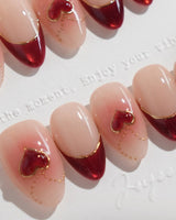 Sweet Venom nail art close-up showing Ruby Red French, gold Outlines, 3D Red Hearts & Shimmering Lines. details