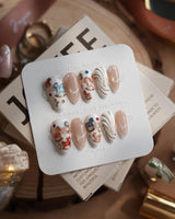 THE REVERIE short almond nails with creamy pearl white, rocking horses, and 3D cream swirls