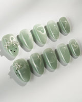 Thump Bunny_Mint press-on nails in extra short almond shape — Sage Green, Velvet Cat Eye Bow.