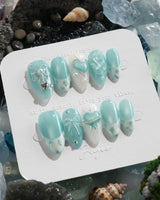 Exuma Blue pastel turquoise nails with sculpted bows, hearts, butterflies, and pearl accents