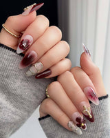 Close-up of Tip Burgundy Nails with burgundy French tips, white base, and gold floral accents