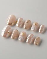 Venus extra short oval press-on nails with pearly nude shell and gold accents