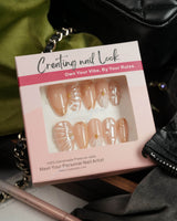 Venus medium almond nails with pearly nude base, shells, and gold details