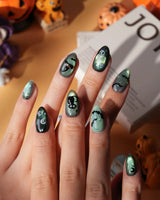 Witch's Cat press on nails with a black cat on a jack-o-lantern, witch hat, skulls, bats and a spider web on green shimmer cat eye - image 2