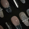 Black and silver press-on nails with glitter French tips, snowflake nail art, chrome accents, and 3D embellishments by Joyee Nails