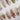 White press-on nail designs from Joyee Nails — milky white, pearl white, chrome white, and bridal French tip styles arranged on a neutral background