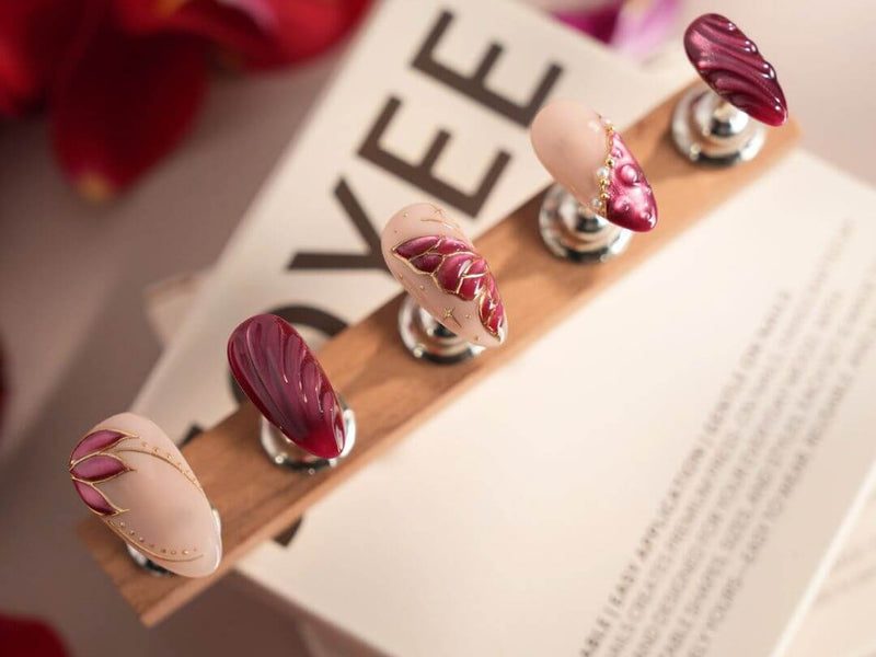 Cherry red and burgundy handmade press-on nails from the Joyee Nails YOU RED collection showing the 2026 moody luxe color trend