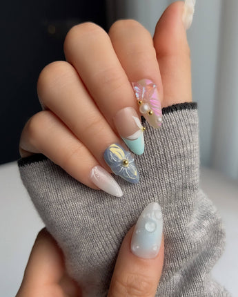 Aqua Petal glossy party nails with pearly pastels and sculpted butterfly accents