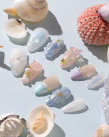 Aqua Petal short almond nails with pearly pastels, 3D flowers, and butterfly accents