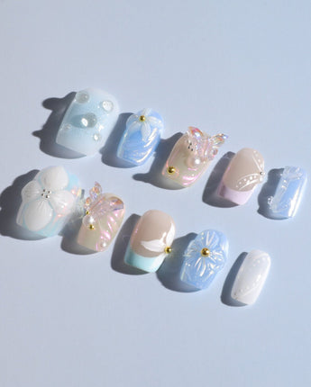 Aqua Petal delicate pastel manicure with sculpted flowers, butterflies, and pearly shine
