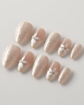Spiral Twist press-ons with soft pearly texture, nude base, and daisy gel accents