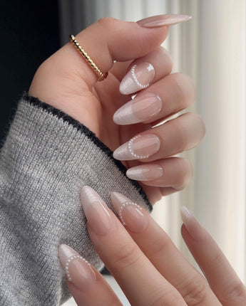 Close-up of Dew Sparkle nude French nails with pearl details and glossy silk texture